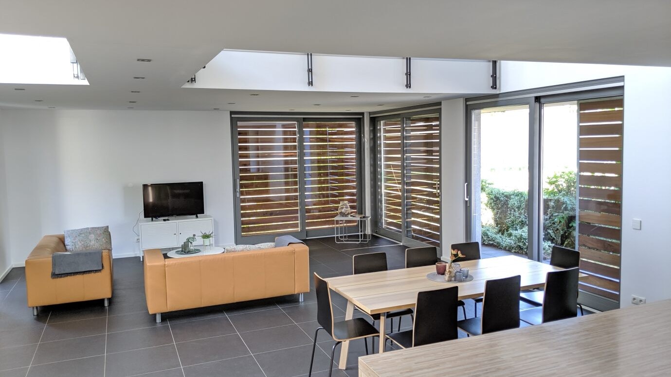 Offener Wohnbereich mit großen Fenstern –