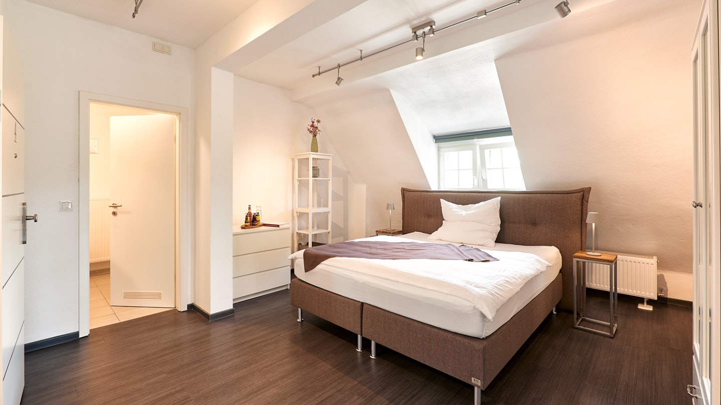 Helles Schlafzimmer unter gemütlichen Dachbalken –