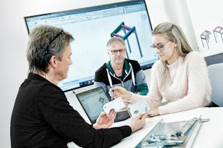 BITO Beratung zur Lagerplanung Eine Beratungssituation zur Lagerplanung, bei der zwei Fachleute und eine Ingenieurin technische Zeichnungen und Bauteile besprechen