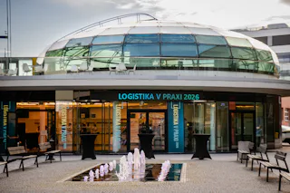 Místo, kde začíná Logistika v praxi 2026 Vstup do konferenčního prostoru s označením Logistika v praxi 2026, prosklenou kopulí, fontánou a venkovním posezením.