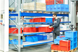 Dos personas trabajan con contenedores de almacenamiento