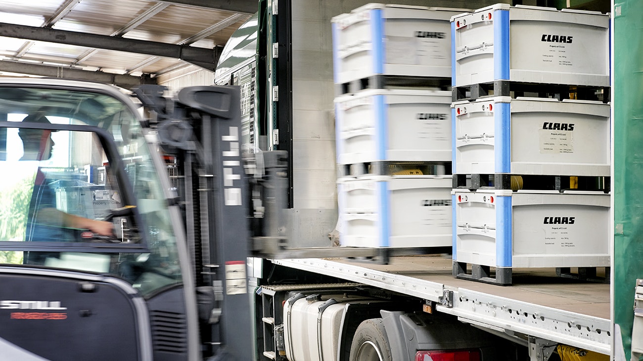 Ein Mann, der mit Hilfe eines Flurförderzeuges, BITO Schwerlastbehälter SL in einen LKW stellt.