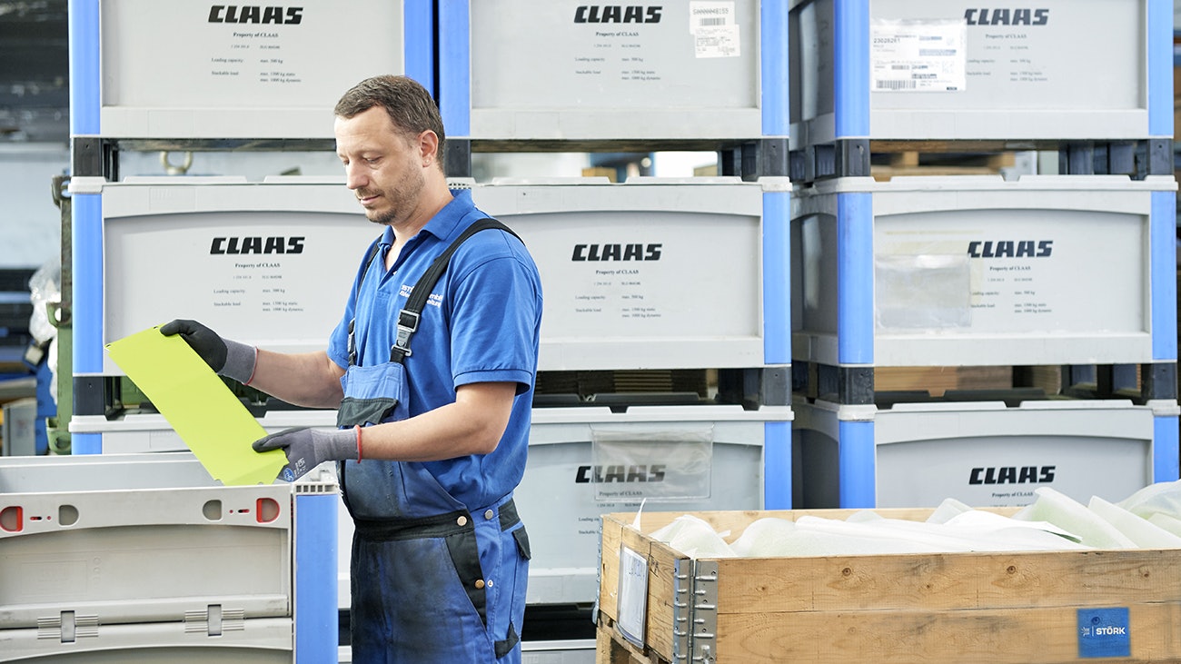 Ein Mann der Teile in einen BITO Schwerlastbehälter packt.