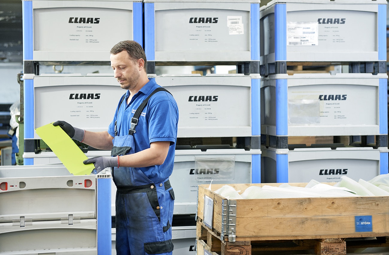 Ein Mann der Teile in einen BITO Schwerlastbehälter packt.