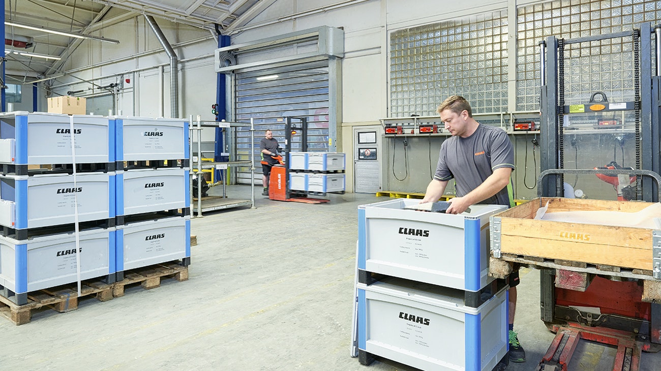 Zwei Arbeiter beim Be- und Verladen von BITO Schwerlastbehältern SL