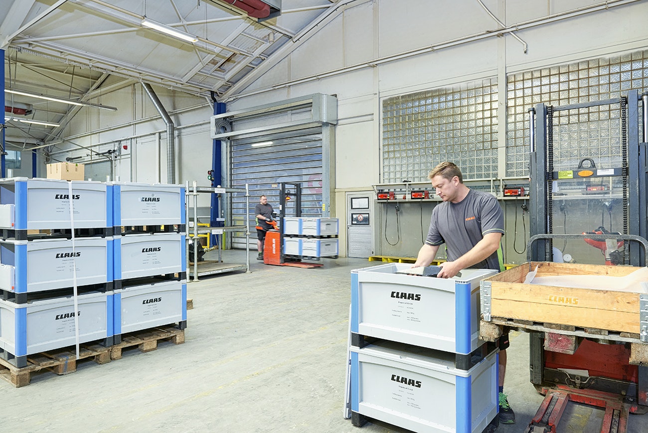 Zwei Arbeiter beim Be- und Verladen von BITO Schwerlastbehältern SL