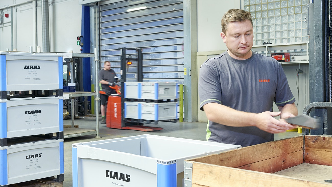 Ein Mann der Teile in einen BITO Schwerlastbehälter packt.