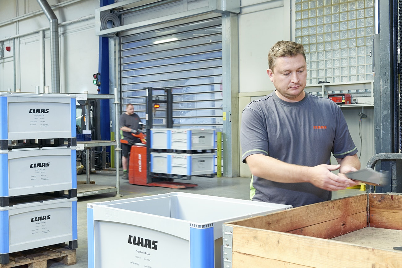 Ein Mann der Teile in einen BITO Schwerlastbehälter packt.