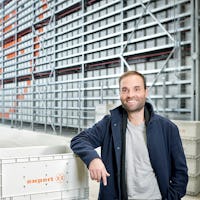 Ein Mann mit BITO Behältern vor einem BITO Regal mit BITO Behältern und Regalsicherheitsnetz