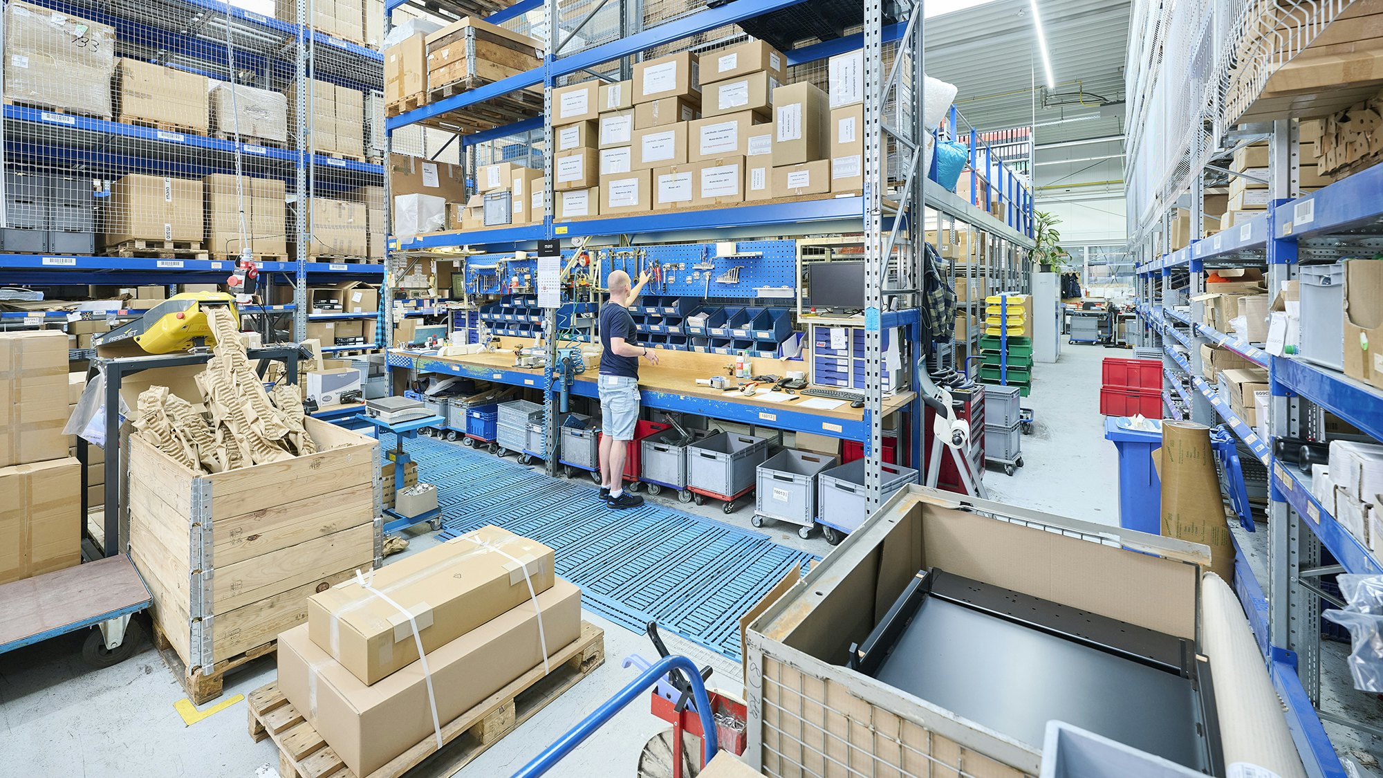 Ein Mitarbeiter an einer Werkbank in einem Palettenlager