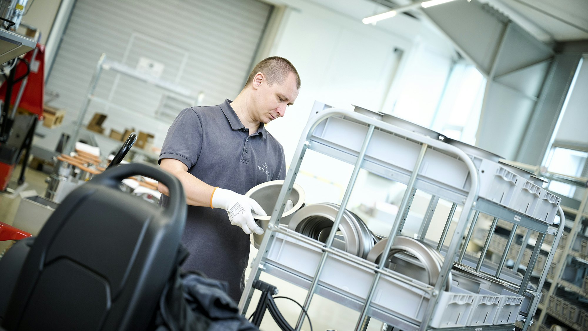 Ein Lagerarbeiter an einem BITO Durchlaufregal mit BITO Stapelbehälter