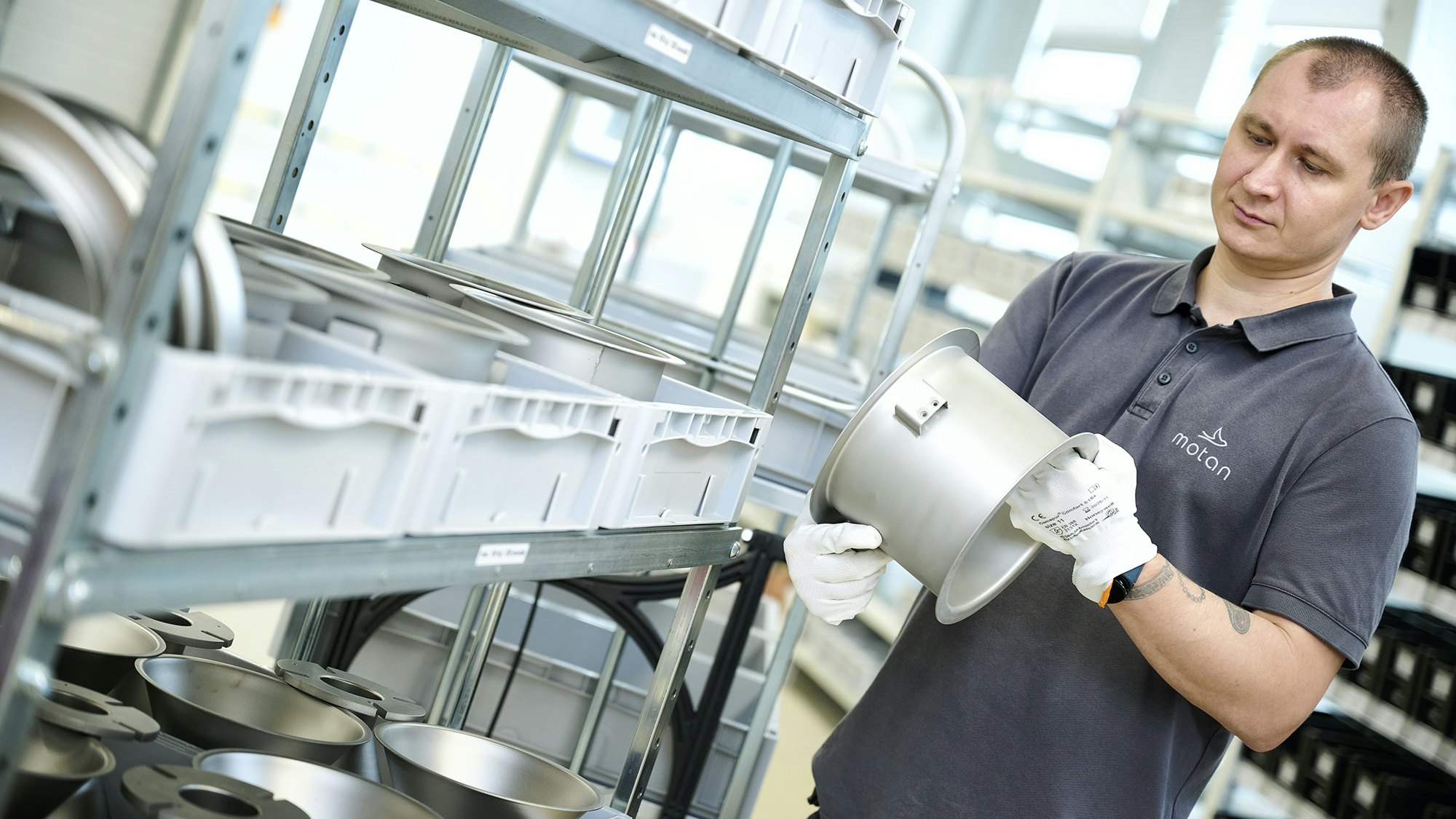 Ein Lagerarbeiter an einem BITO Durchlaufregal mit BITO Stapelbehälter