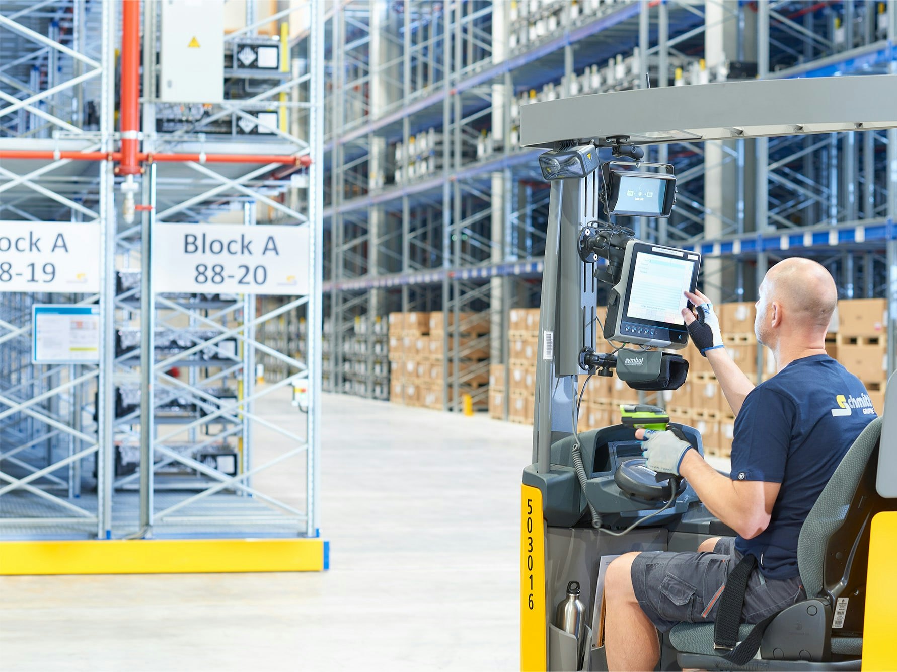 Ein Lagerarbeiter in einem Flurförderzeug vor Verfahrbaren BITO Palettenregalen