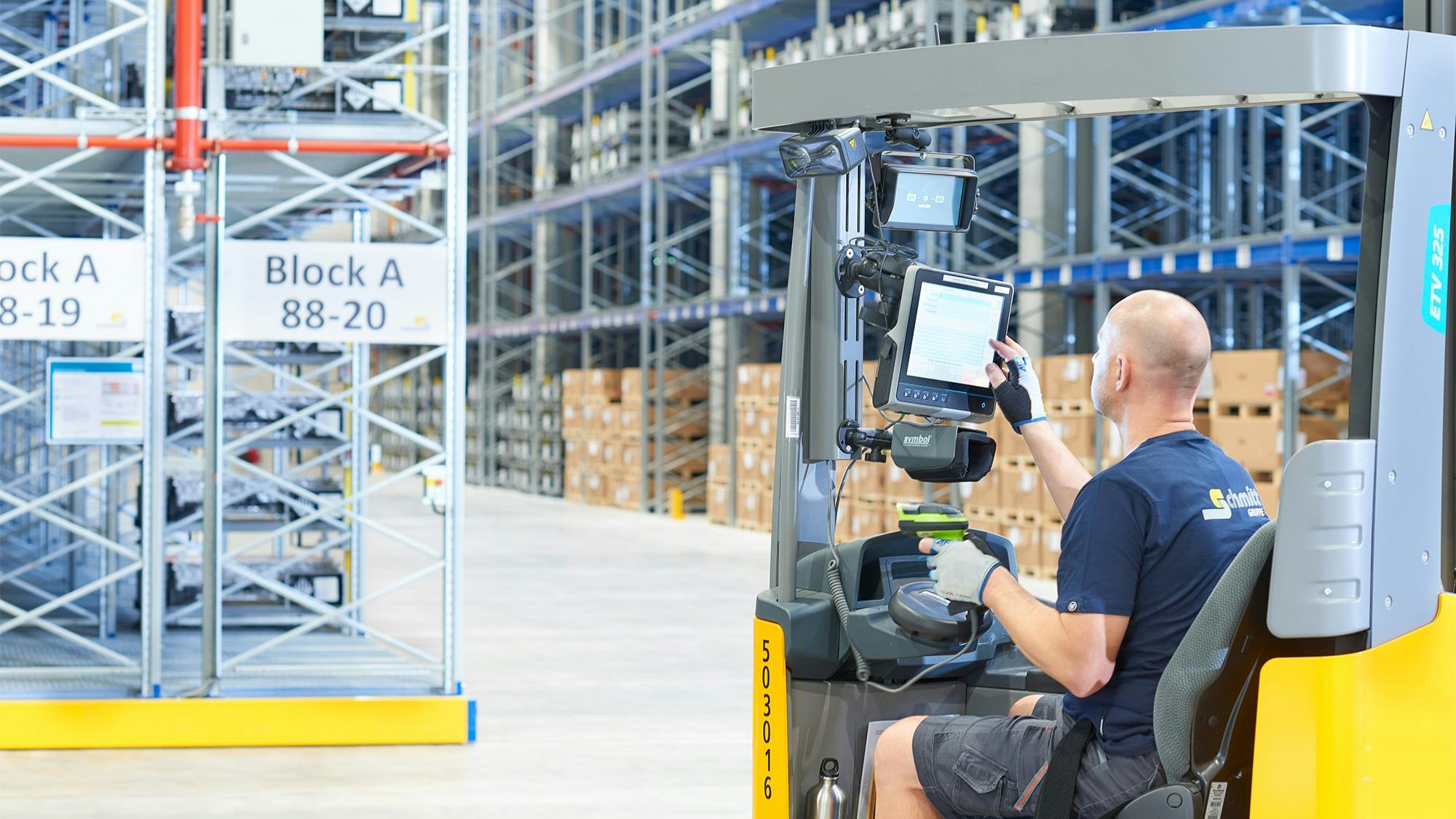 Ein Lagerarbeiter in einem Flurförderzeug vor Verfahrbaren BITO Palettenregalen
