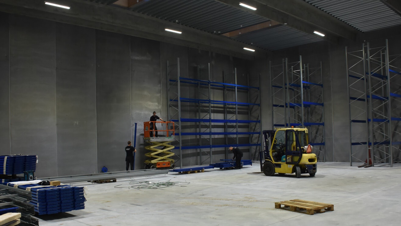 Drei Monteure beim Aufbau von Palettenregalen