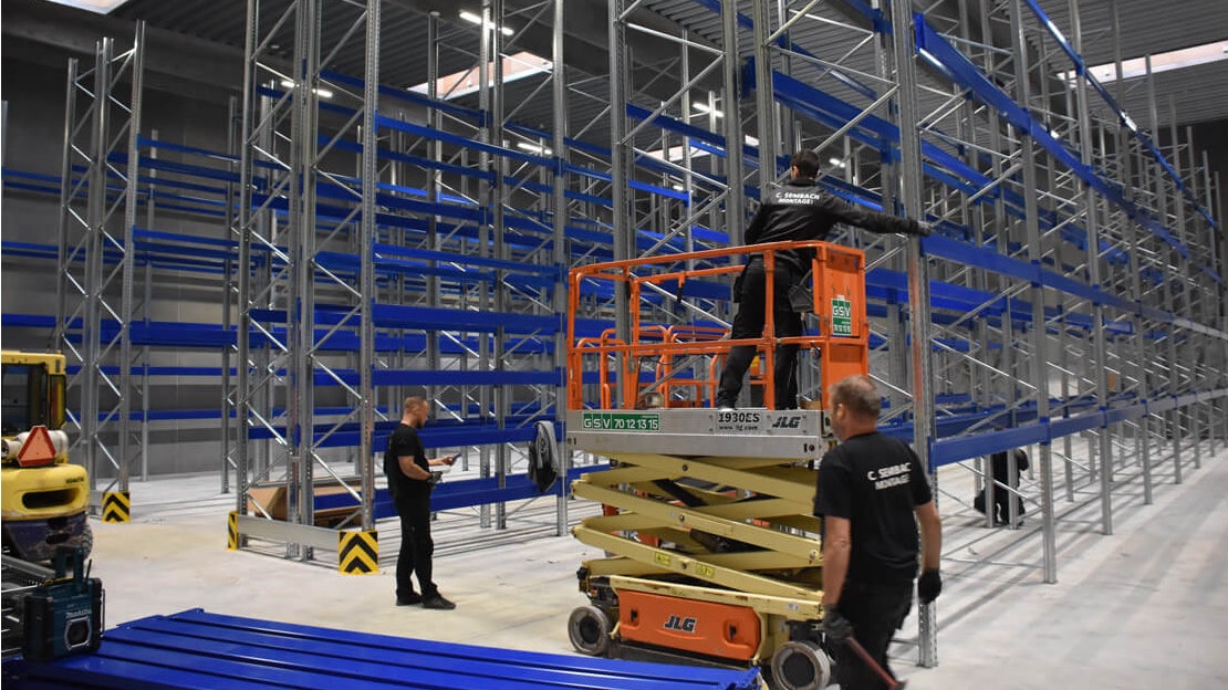 Drei Monteure beim Aufbau von Palettenregalen