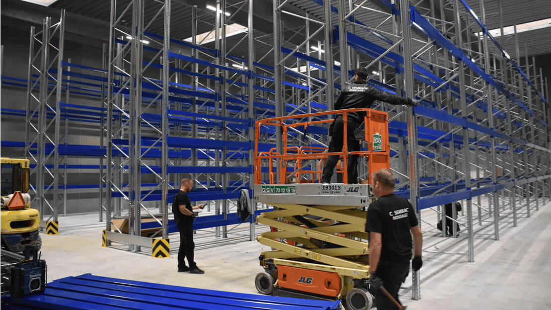 Drei Monteure beim Aufbau von Palettenregalen