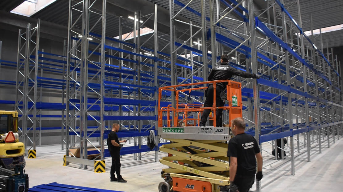 Drei Monteure beim Aufbau von Palettenregalen