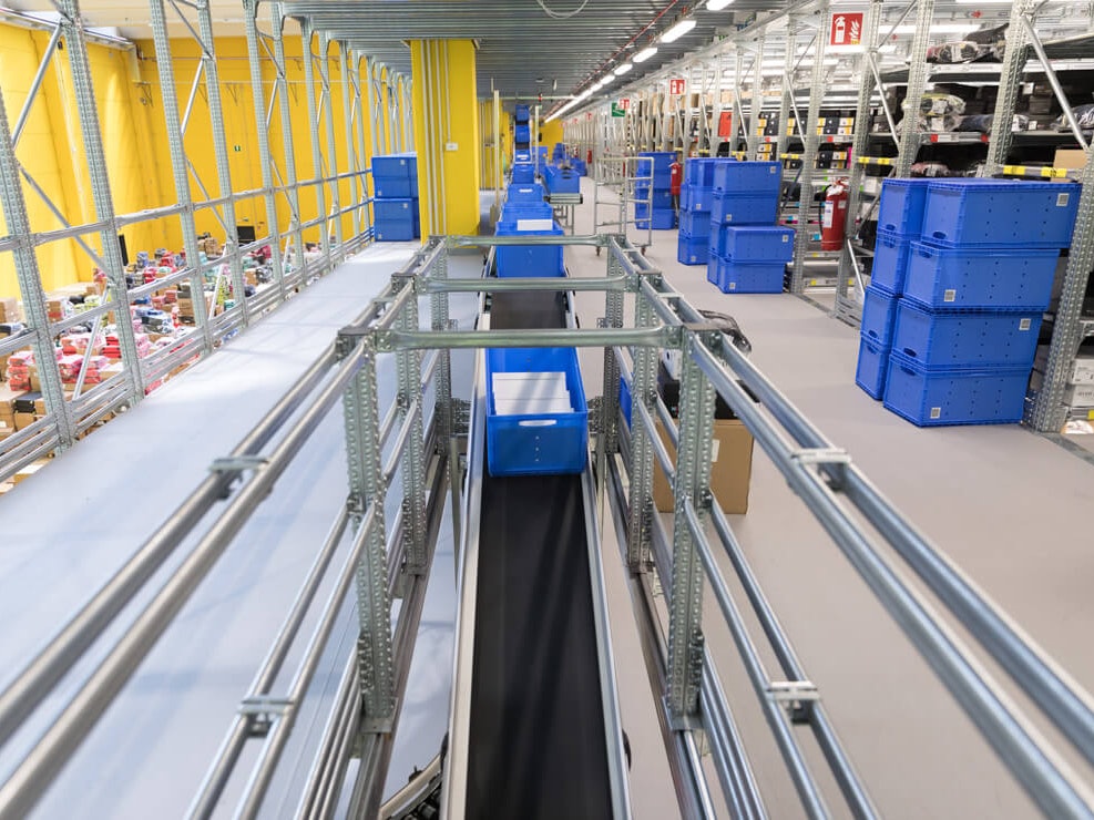 BITO Eurostapelbehälter auf einem Förderband, im Hintergrund Fachbodenregale