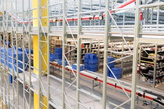 BITO Eurostapelbehälter vor und auf einer Rollenbahn, im Hintergrund stehen Fachbodenregale