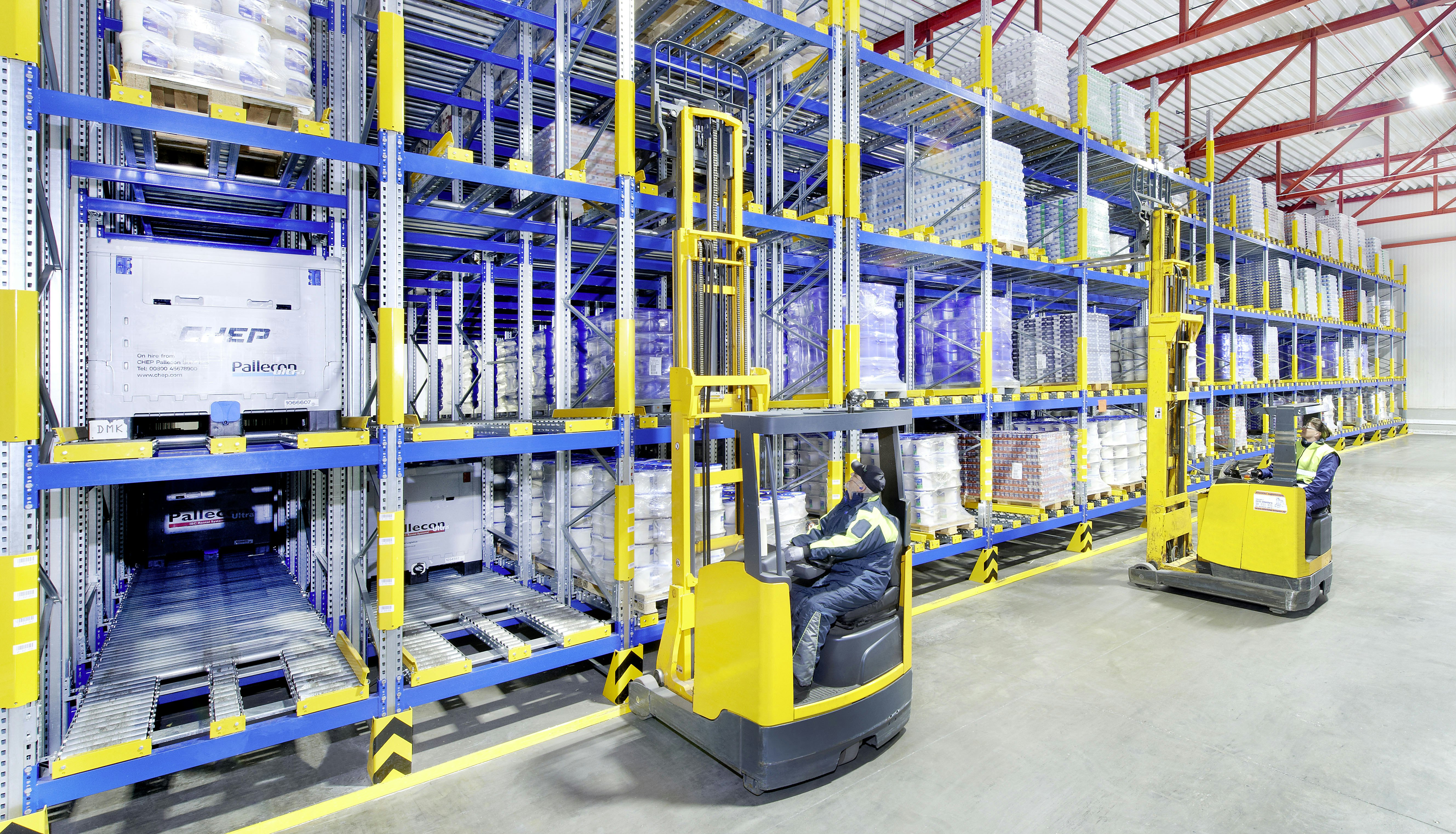 Rayonnage dynamique palettes BITO Zwei Arbeiter auf Flurförderzeugen an einem Palettendurchlaufregal