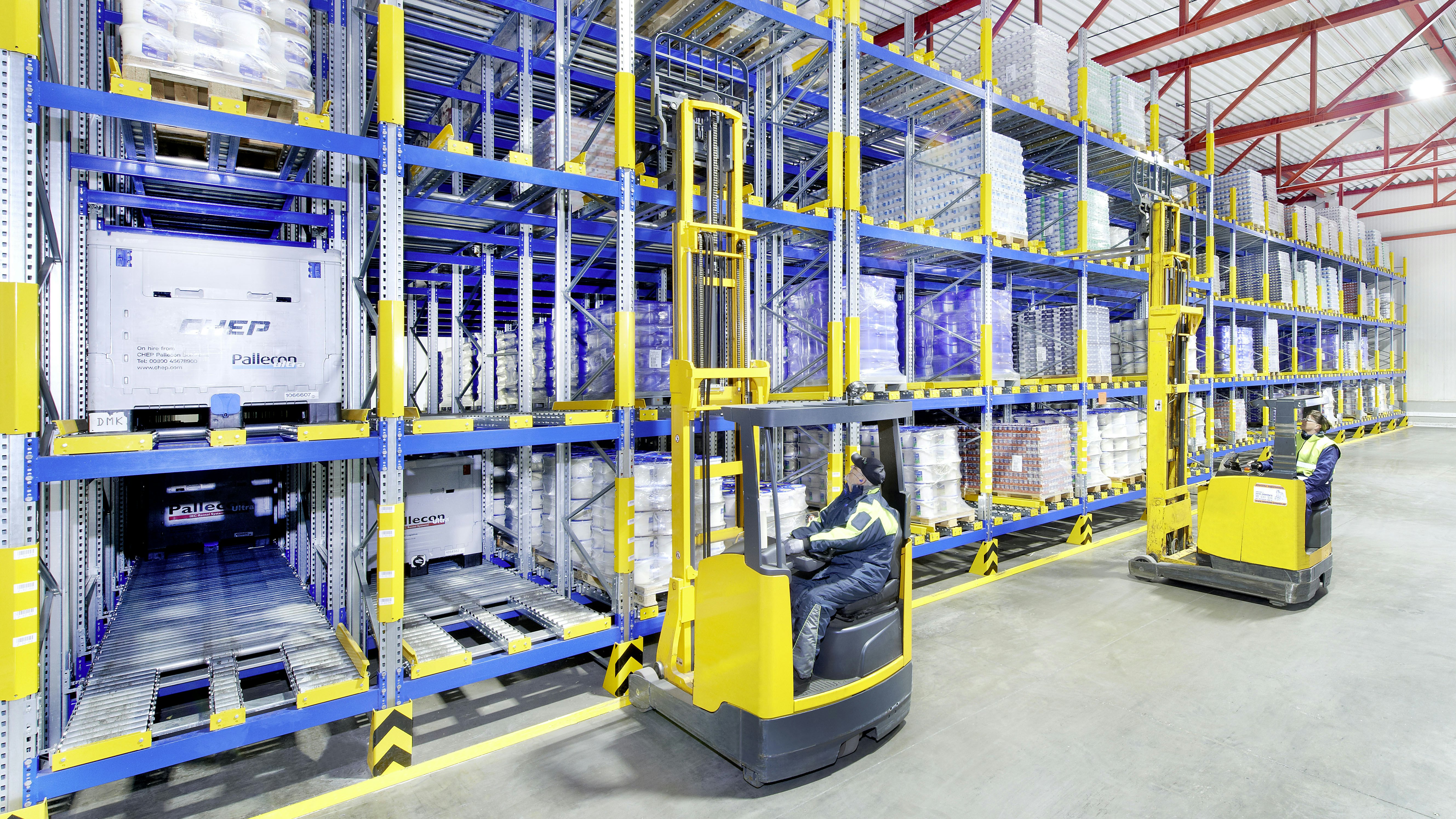 Rayonnage dynamique palettes BITO Zwei Arbeiter auf Flurförderzeugen an einem Palettendurchlaufregal