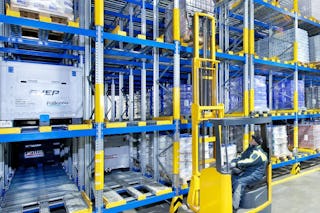 Zwei Männer auf Flurförderzeugen an einem Palettendurchlaufregal