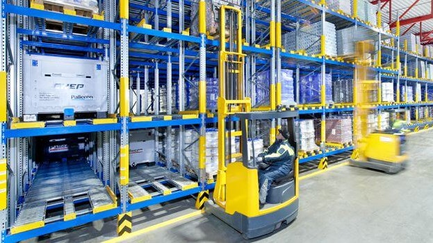 Zwei Männer auf Flurförderzeugen an einem Palettendurchlaufregal