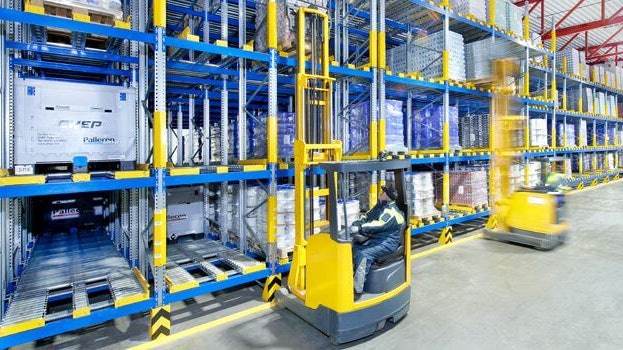 Zwei Männer auf Flurförderzeugen an einem Palettendurchlaufregal