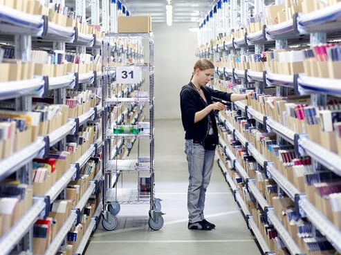 Eine Mitarbeiterin an einem Fachbodenregal