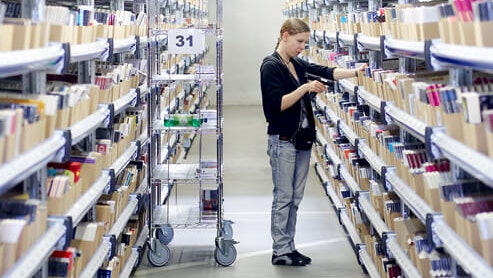 Eine Mitarbeiterin an einem Fachbodenregal