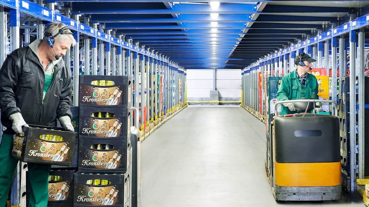 Mitarbeiter entnehmen Getränkekisten aus einem Palettendurchlaufregal von BITO