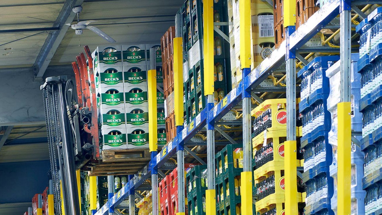 Mitarbeiter entnehmen Paletten mit Getränkekisten aus einem Palettendurchlaufregal von BITO