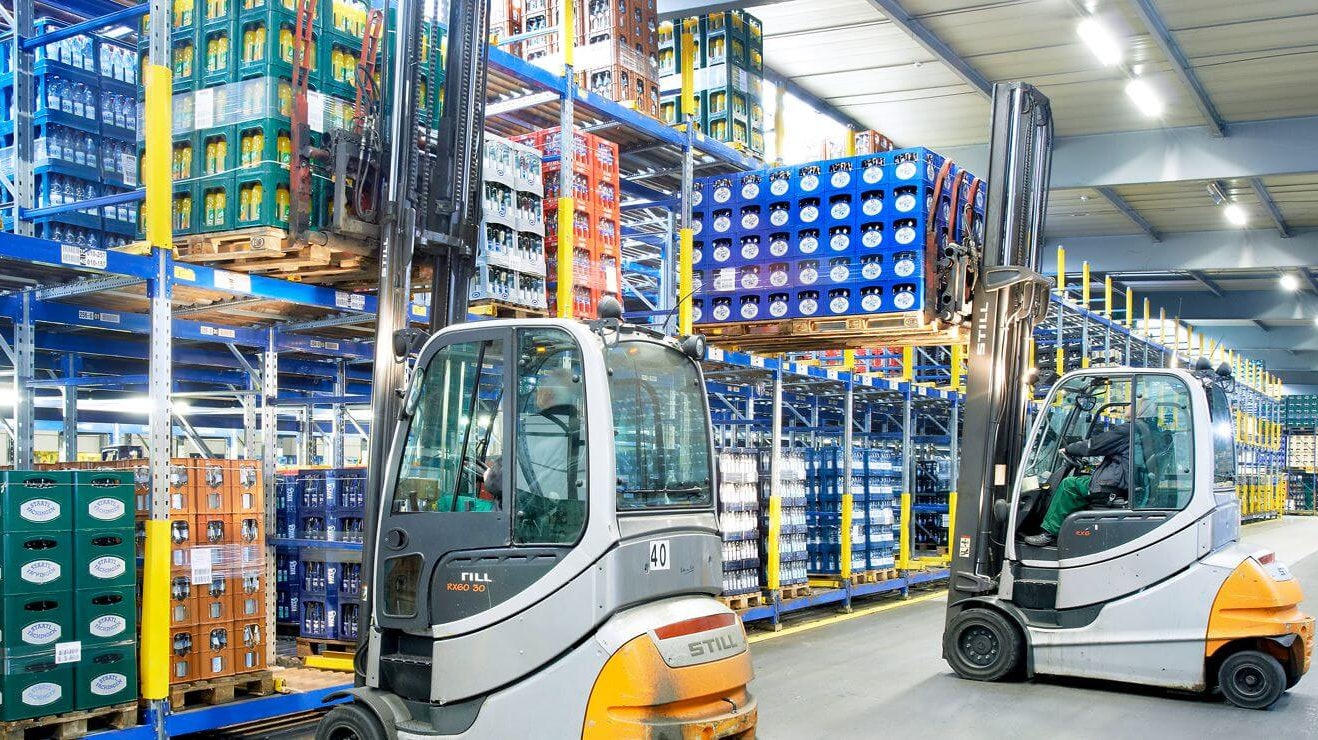 Mitarbeiter entnehmen Paletten mit Getränkekisten aus einem Palettendurchlaufregal von BITO