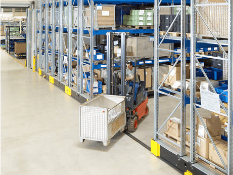 Ein Mitarbeiter auf einem Flurförderzeug in einem Platzsparendem Verfahrbaren Palettenregal von BITO