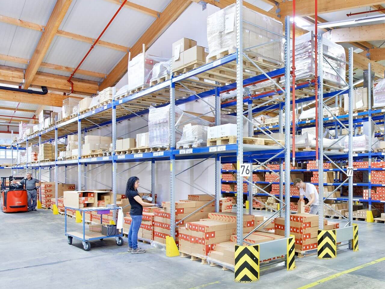 Mehrere Mitarbeiter in einem Palettenregal