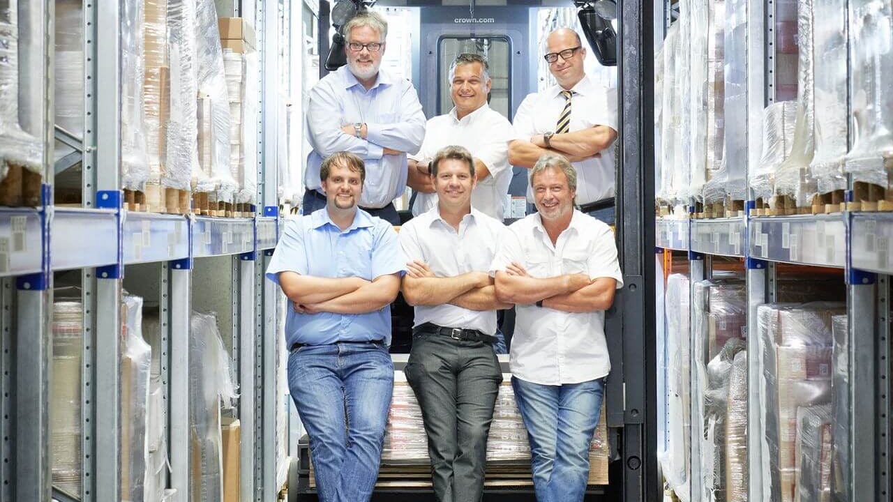 Mehrere Personen zwischen zwei Palettenregalen