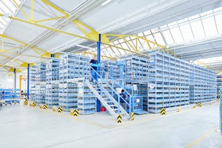 Mitarbeiter an einer Mehrgeschossanlage mit Fachbodenregalen