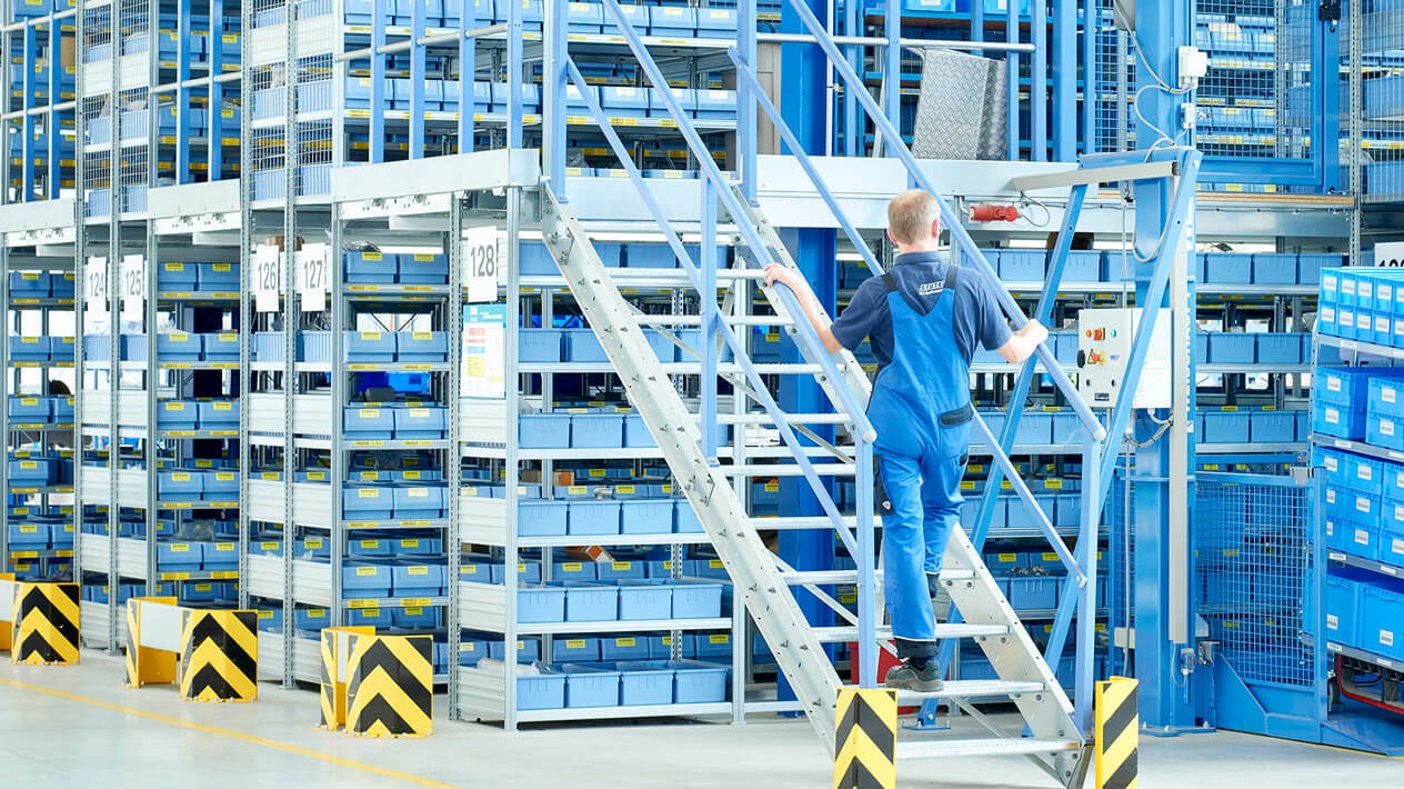 Mitarbeiter an einer Mehrgeschossanlage mit Fachbodenregalen