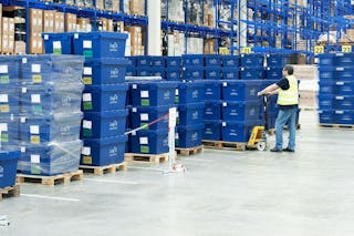 Mitarbeiter mit Flurförderzeugen beim Aufnehmen von Paletten, voll mit BITO Mehrwegbehältern; vor einem BITO Palettenregal