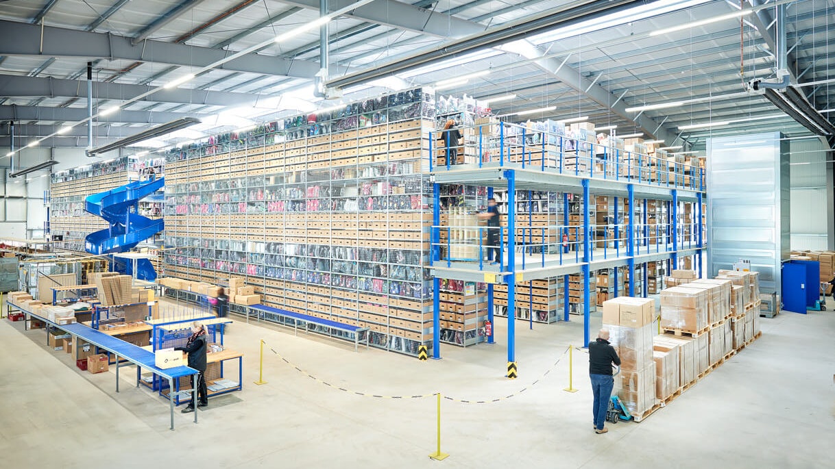 Mehrere Personen bei der Arbeit an einer Mehrgeschossanlage / Fachbodenregal