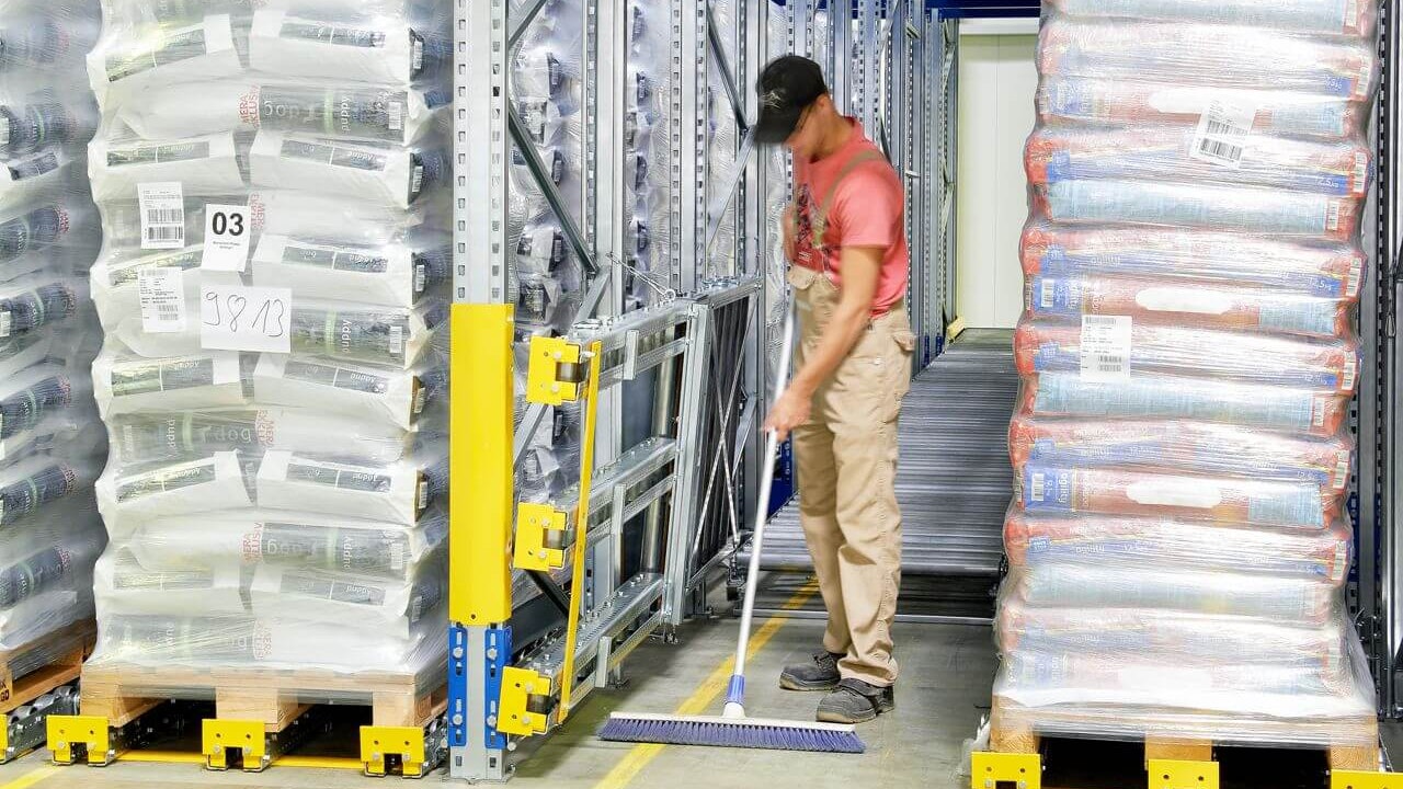 Ein Mitarbeiter beim Reinigen des Umfeldes rund um ein BITO Paletten-Durchlaufregal