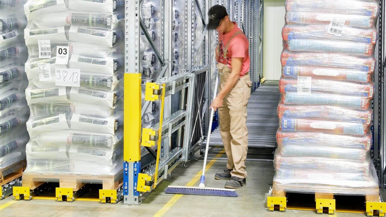 Ein Mitarbeiter beim Reinigen des Umfeldes rund um ein BITO Paletten-Durchlaufregal