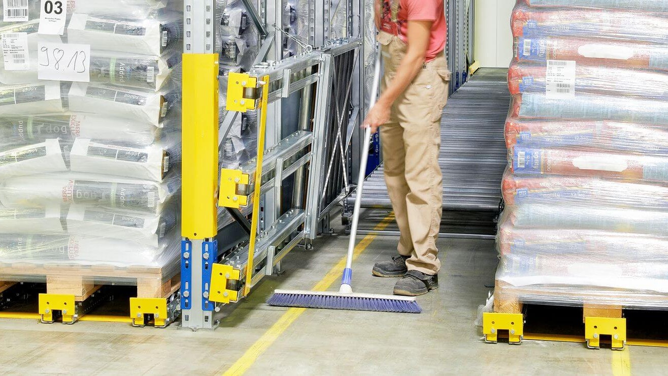 Ein Mitarbeiter beim Reinigen des Umfeldes rund um ein BITO Paletten-Durchlaufregal