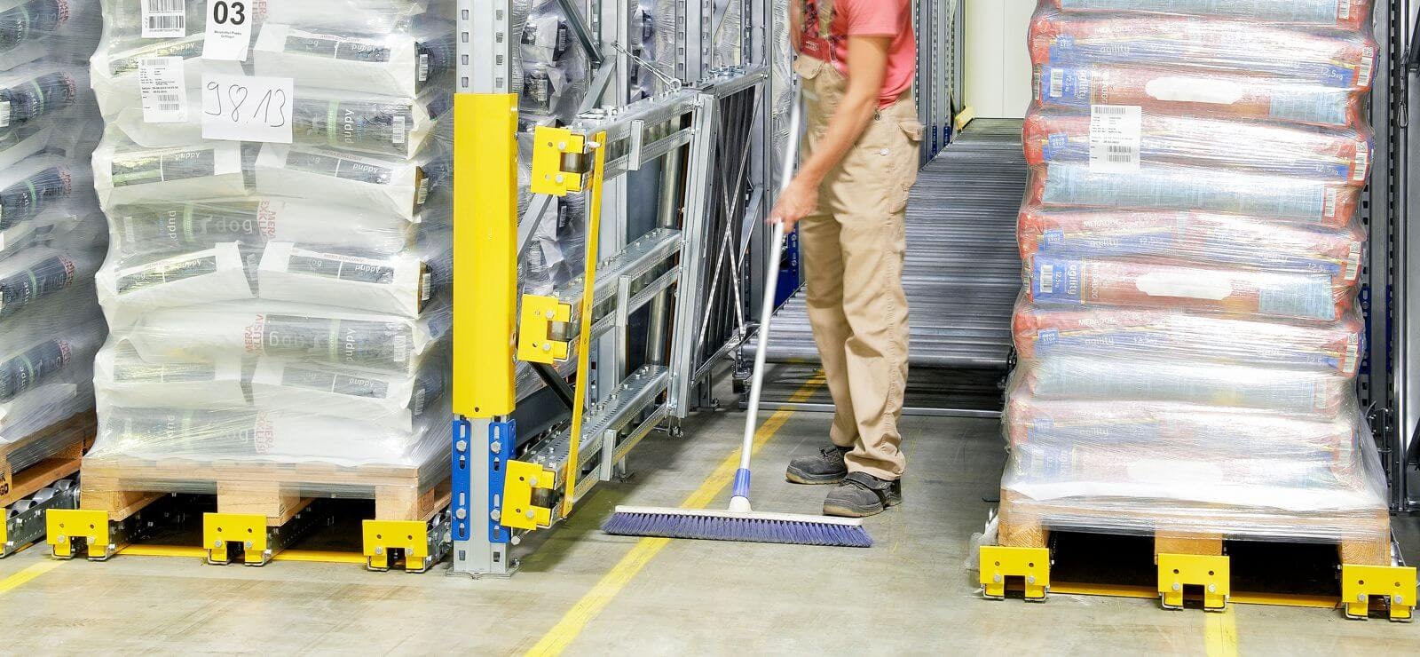 Ein Mitarbeiter beim Reinigen des Umfeldes rund um ein BITO Paletten-Durchlaufregal