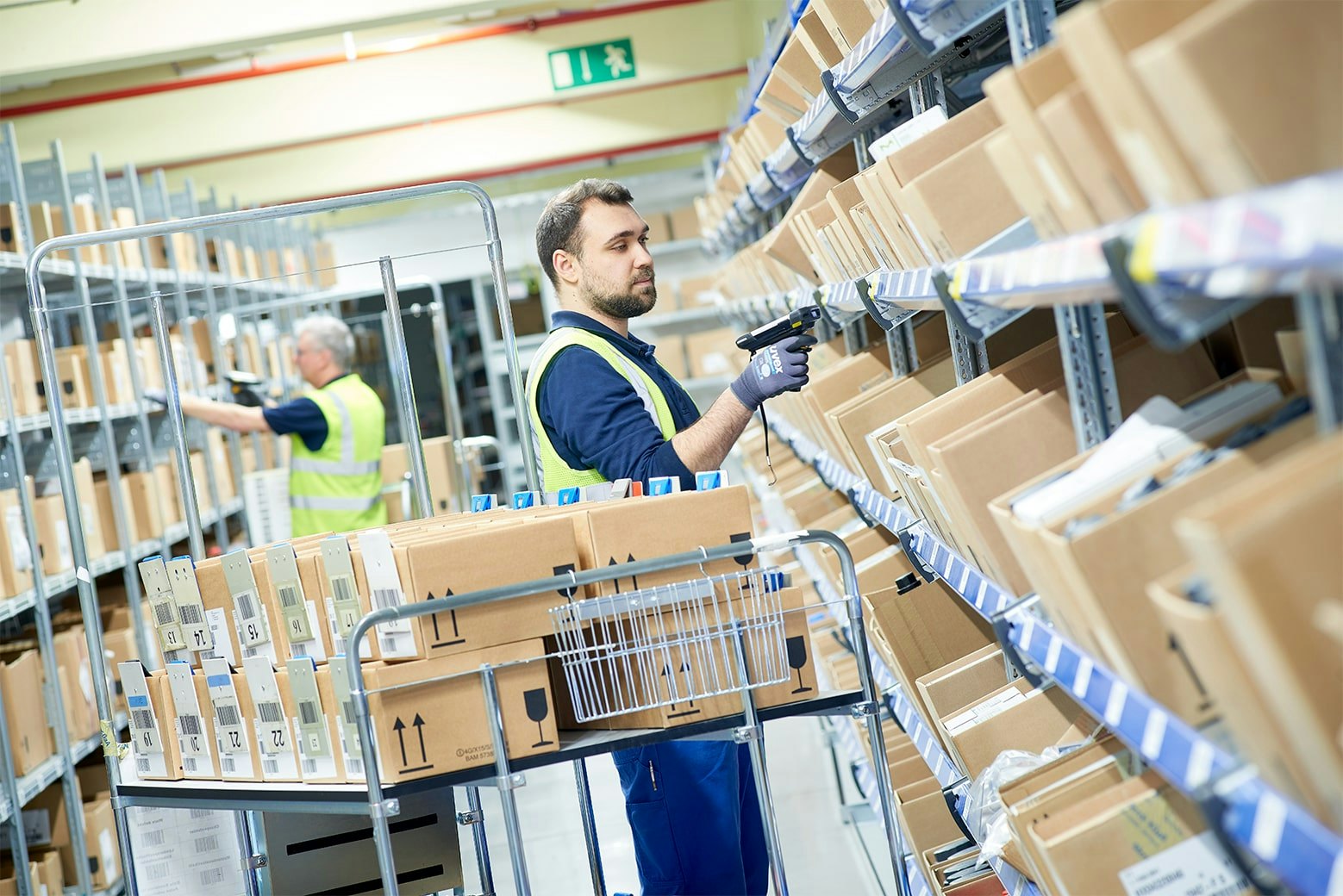 Zwei Mitarbeiter an BITO Durchlaufregalen mit Schrägböden