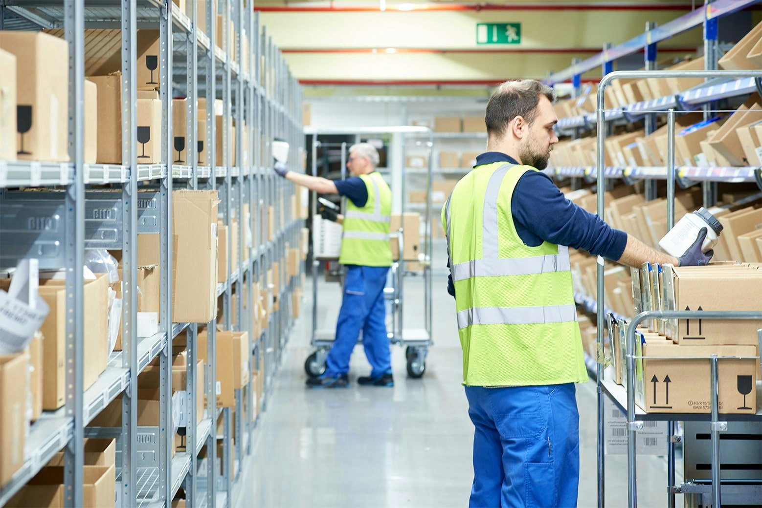 Zwei Mitarbeiter an BITO Durchlaufregalen mit Schrägböden