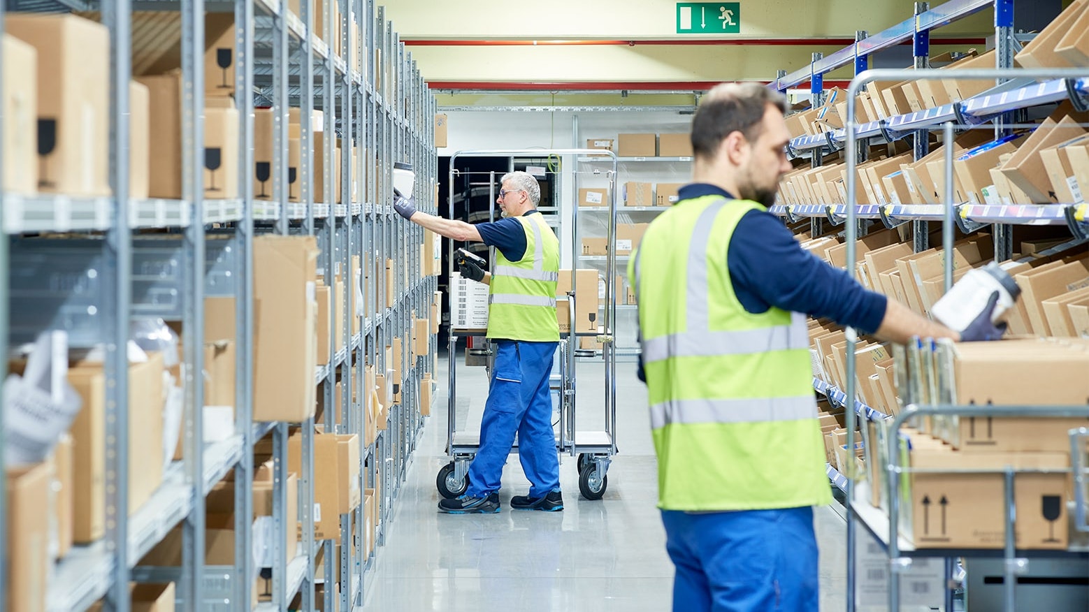 Zwei Mitarbeiter an BITO Durchlaufregalen mit Schrägböden