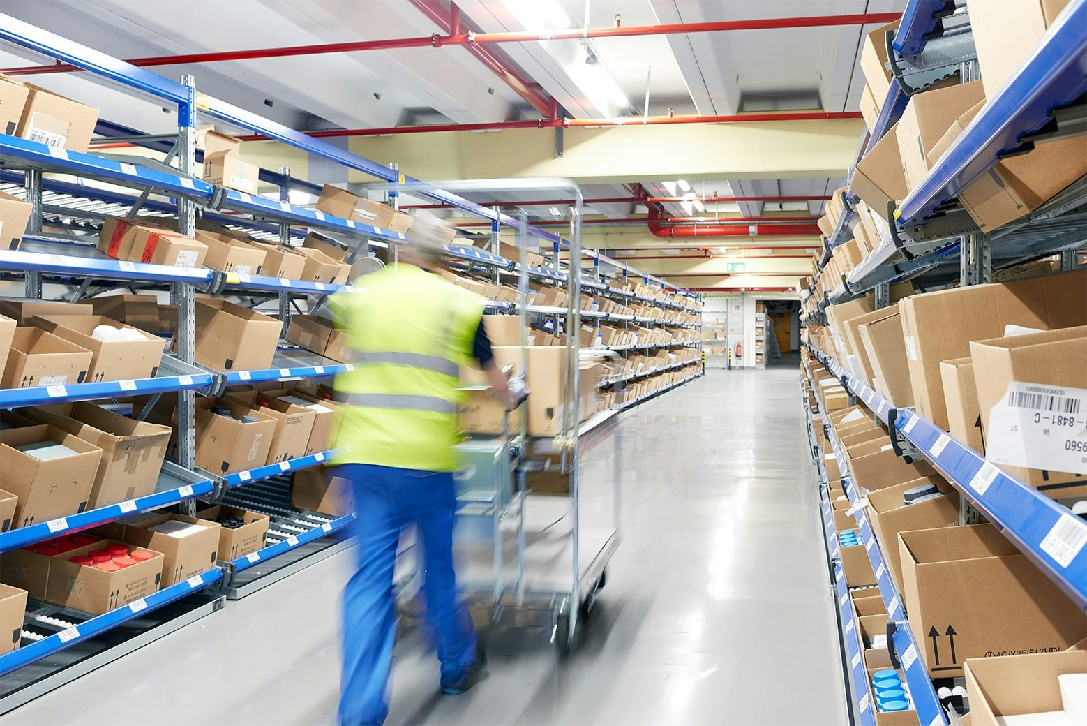 Ein Arbeiter an einem BITO Durchlaufregal mit Schrägböden