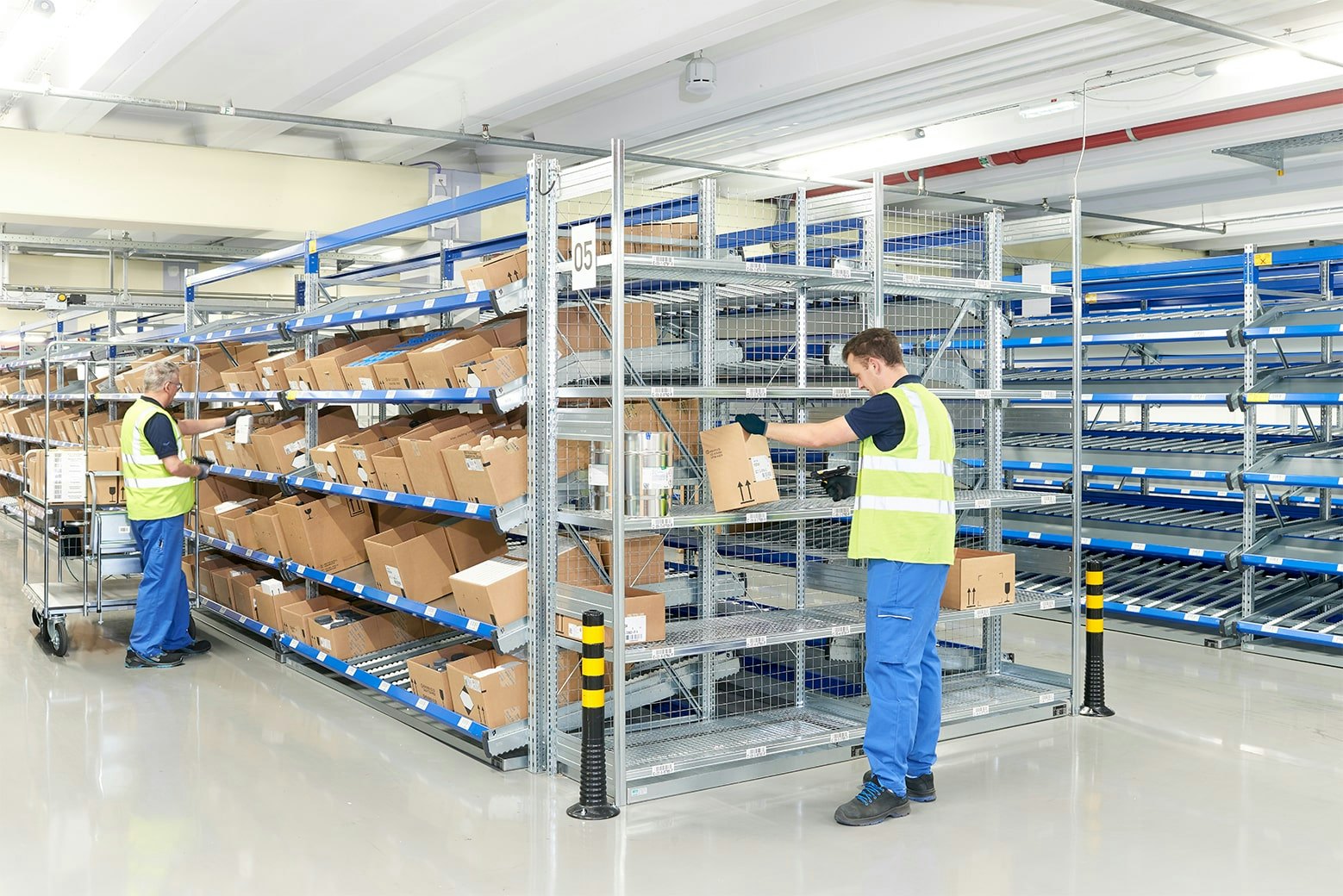 Zwei Personen an einem BITO Durchlaufregal mit Schrägböden